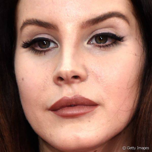 Lana Del Rey equilibrou as aten??es da maquiagem entre os olhos delineados e os l?bios real?ados por batom marrom no Golden Globe Awards 2015